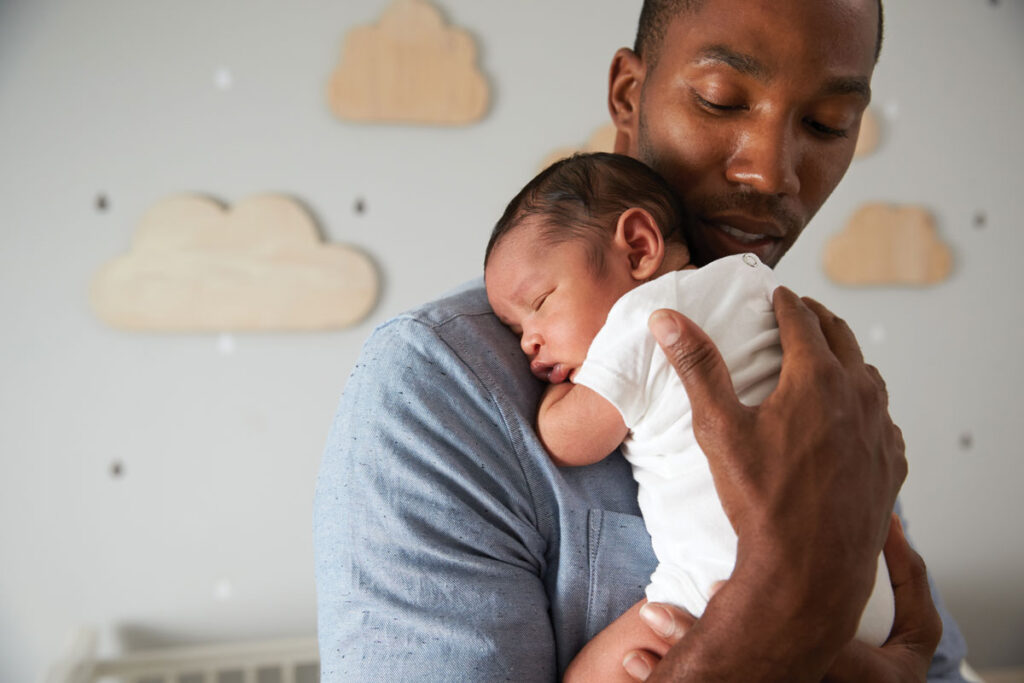 Father holding newborn child in a nursery