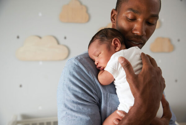 Father holding newborn child in a nursery