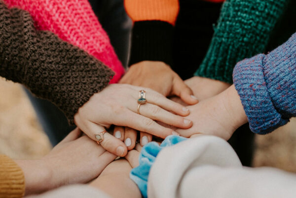 girl friends hands piled togethger