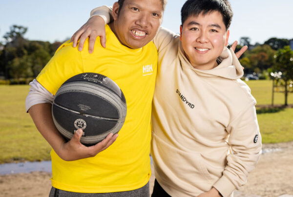 Two young men with their arms around each others shoulders